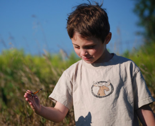 An image of a young child, standing outdoors is shown.