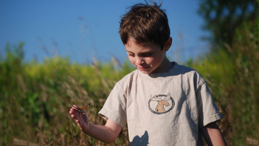 An image of a young child, standing outdoors is shown.