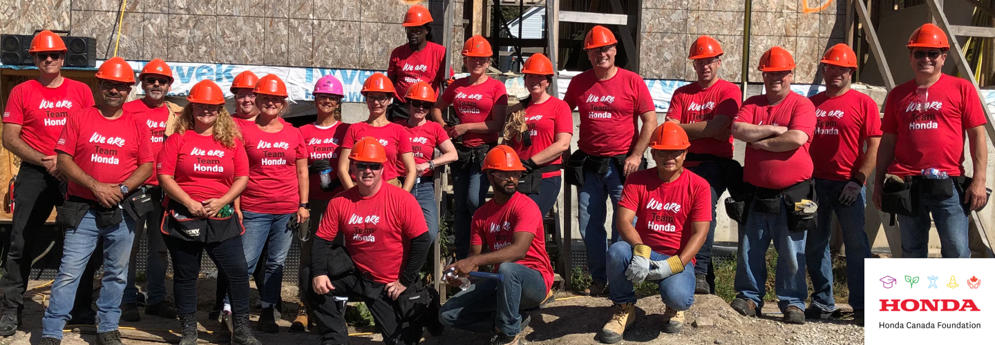 An image of a smiling group of Honda employees posing is shown. 