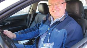 A man smiles as he sits behind the wheel of a Honda vehicle. 